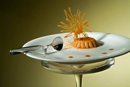 Caramel cream on a plate with a spoon and Carameliesd  Decoration