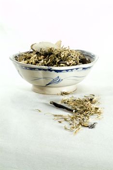Medical chinese herbs in an ancient Chinese ceramic bowl.