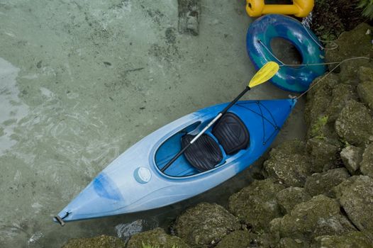 A kayak and tubes on the sandy side of a Florida spring.