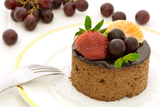 Chocolate cake decorated with strawberry, grape and tangerine slice