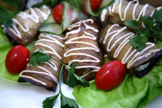 Eggplants filled by cheese and garlic on leaves of salad