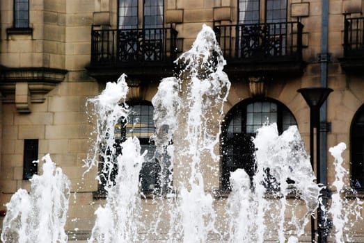 A photograph of fountains in the Peace Gardens in Sheffield, England, with the Town Hall in the background.