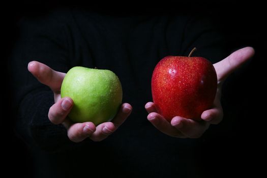 Man's hand with a two apples on a black background