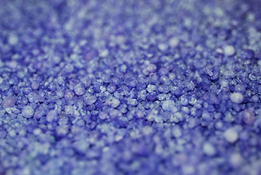 A bluish purple background photograph of granules