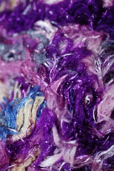 A close-up photograph of purple and mixed coloured fibres