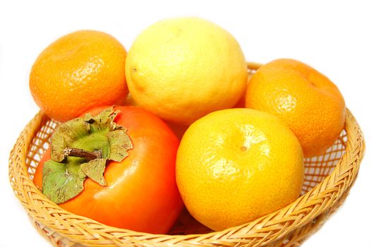 Tangerine,persimmon,lime in wattled basket
