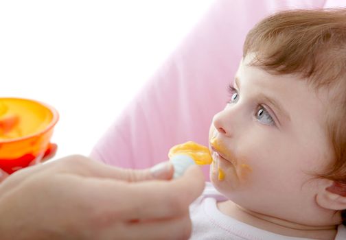 mother feeding baby yellow spoon white background