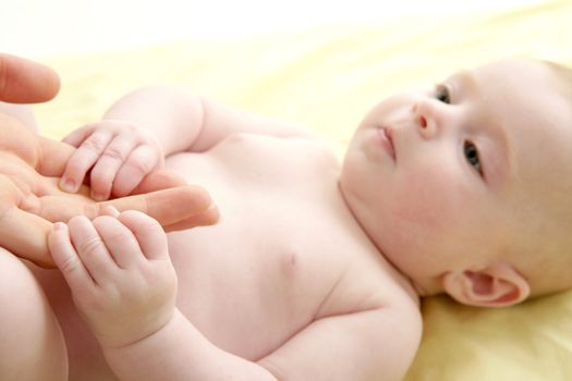 nude blond baby playing mother hands together