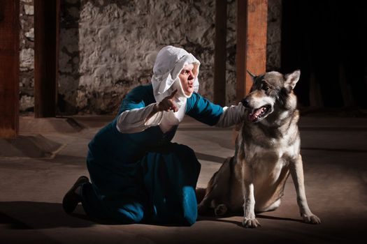 Kneeling middle ages nun character giving commands to a dog