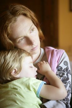 Baby toddler girl sleeping in redhead mother arms tranquil scene