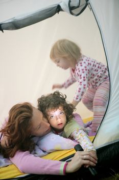 Camping tent vacation with mother and two little daughters
