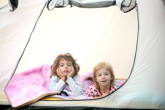 Camping tent vacation with two little beautiful girls in nature