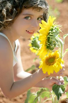 Beautiful little girl in a summer sunflower colorful field