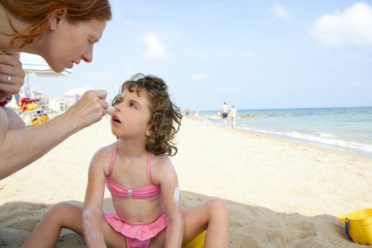 Daughter and mother on the beach sun screen protection moisture cream