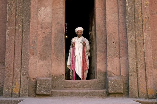 priest at ancient rock hewn churches of lalibela in ethiopia