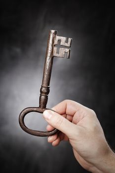 Man holding big old antique key in his hand.