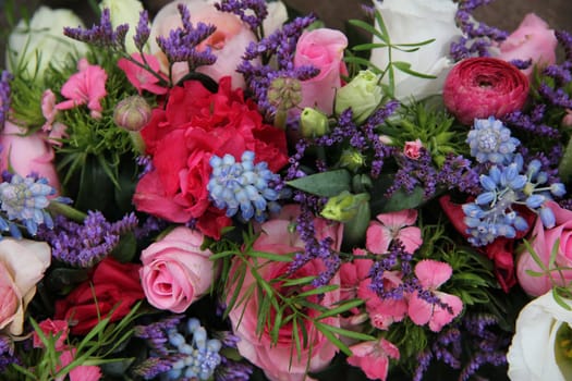 pink roses and ranonkels, blue common hyacints in a spring flower wedding centerpiece