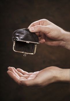 Man holding an empty small change coin  purse in his hand.