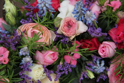 pink roses and ranonkels, blue common hyacints in a spring flower wedding centerpiece