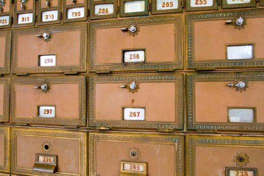 This photo shows the many po boxes at the post office. The mail boxes are lined up in rows and columns for organization.