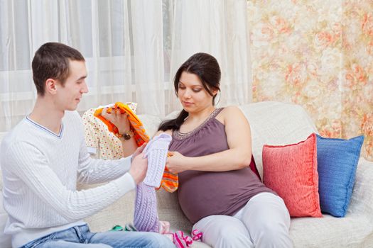 pregnant woman with the husband look clothes for the child