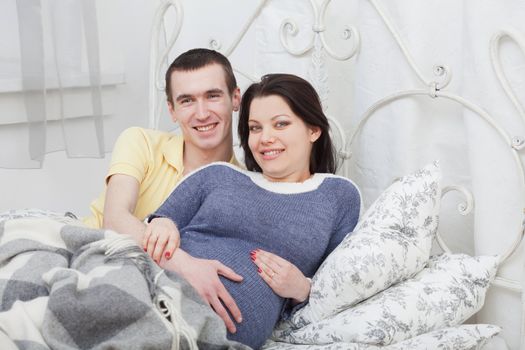 Man embraces pregnant woman. Family happiness
