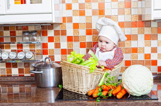 Baby cook with vegetables sits in a wattled basket on a kitchen table