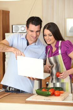 Couple cooking with a laptop