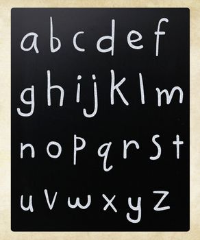 Complete english alphabet handwritten with white chalk on a blackboard