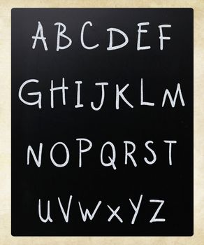 Complete english alphabet handwritten with white chalk on a blackboard