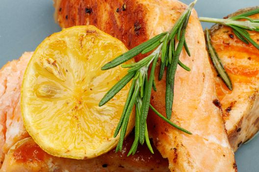 Grilled Salmon with Lemon and Rosemary closeup on Green Plate. Top View