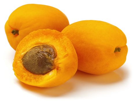 Two and the half of fresh mature apricots on white background.