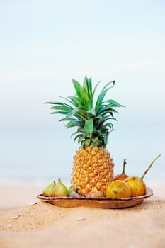 Pineapple and tropical fruit on the leaves plate