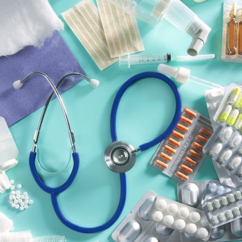 blister of medical pills and pharmaceutical stuff with stethoscope over green background