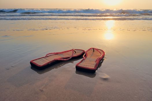 Beach sandals on the sandy beach at the sea