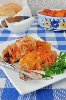 Stuffed cabbage stewed in tomato gravy with onions and carrots on a platter