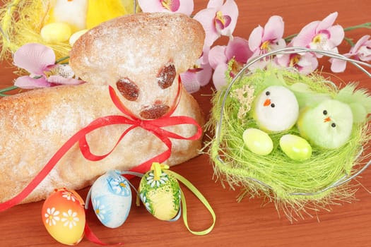 Easter lamb with painted eggs, nest and easter decorations