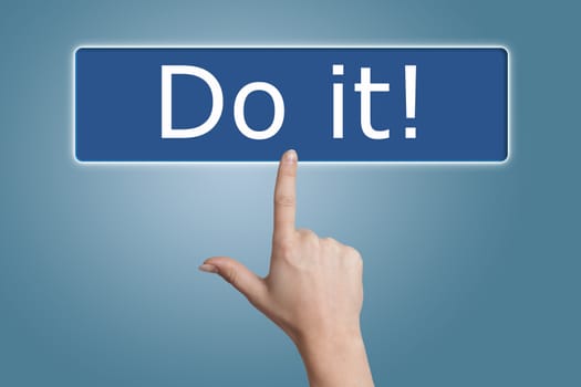 Woman hand pressing a button with word " do it! " on blue background