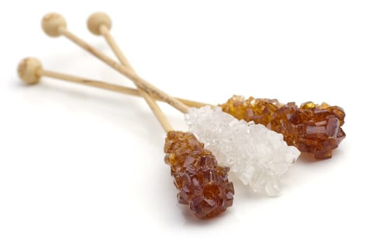 Candy brown and white sugar on a sticks. With white background. Soft focus.
