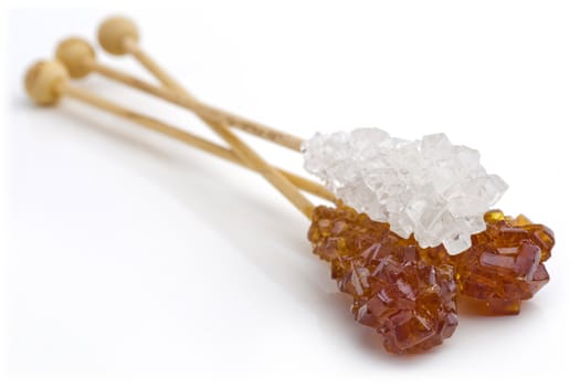 Candy brown and white sugar on a sticks. With white background. Soft focus.