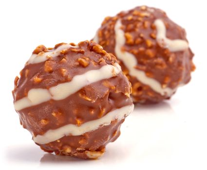 Sweet chocolate balls filled with hazelnuts on a white background.