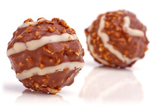 Sweet chocolate balls filled with hazelnuts on a white background.