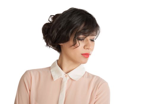 Brunette in a pink blouse looks down on a white background