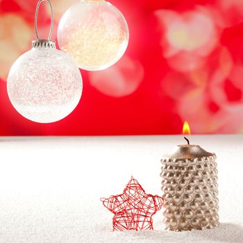 christmas silver candle and red star on snow and red with glass baubles