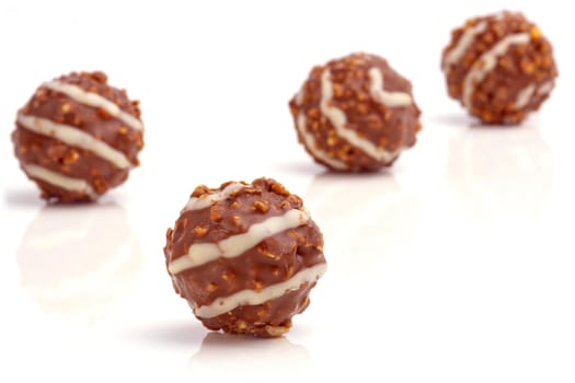 Sweet chocolate balls filled with hazelnuts on a white background.