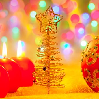 Christmas golden tree with baubles and candles in blur lights