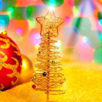 Christmas golden tree with baubles in blur lights background