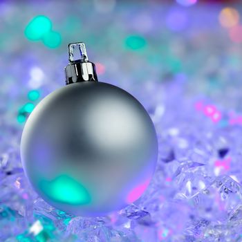 christmas silver bauble on colorful glowing ice cubes