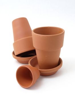 Several different sized terra cotta clay pots isolated on a white background.