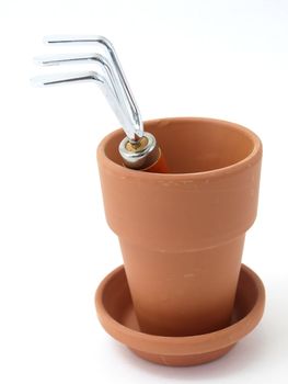 Gardening tool and terra cotta pot and saucer isolated against a white background.